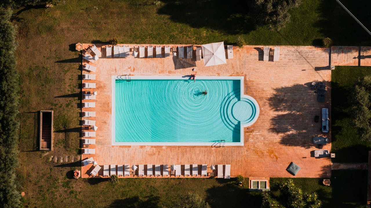 portfolio-06 Stunning aerial view of a resort swimming pool with sunloungers in Puglia, Italy.